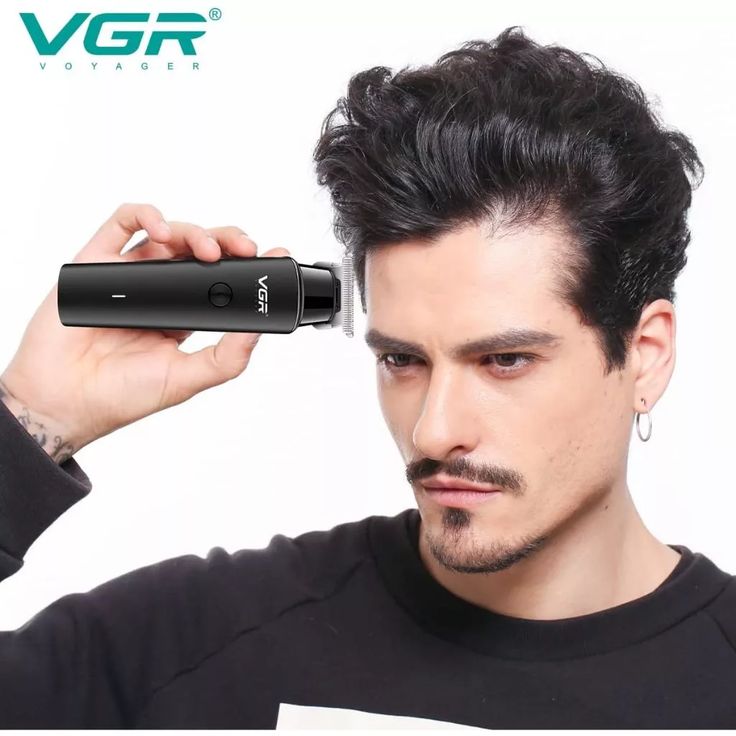 Man holding a VGR grooming haair trimmer device with a white background